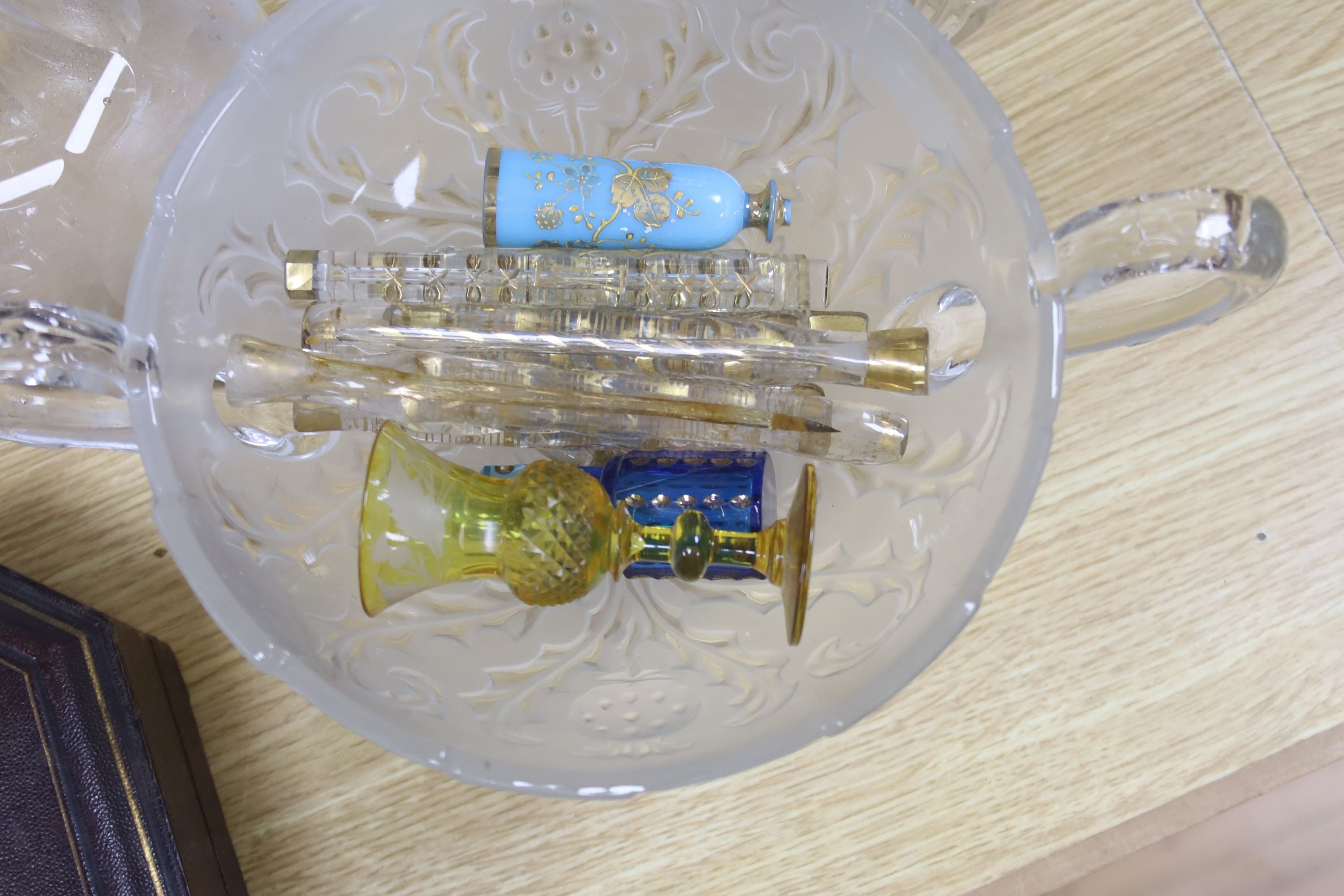 A collection of glass perfume bottles, three decanters, two scent bottles with cut glass stoppers and two handled bowl and an Art Nouveau style vase and plated cruet